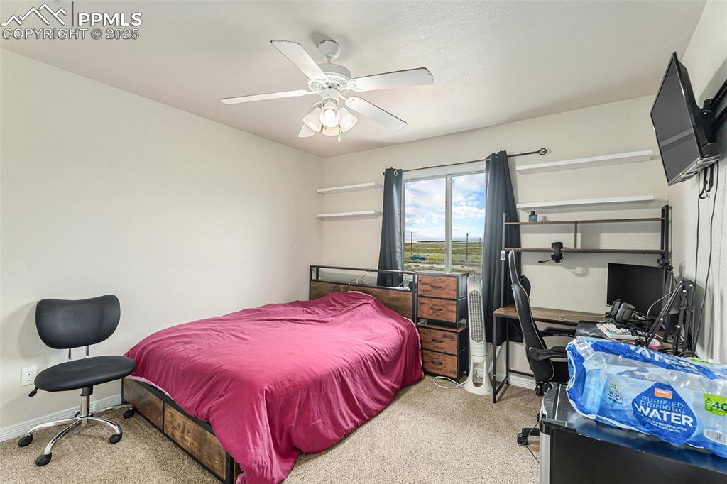 Image 26 of 30: Carpeted bedroom with a ceiling fan
