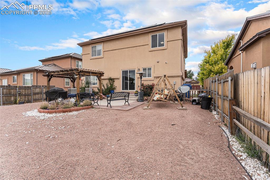 Image 28 of 30: Rear view of house featuring a patio area, a pergola, stucco siding, and a