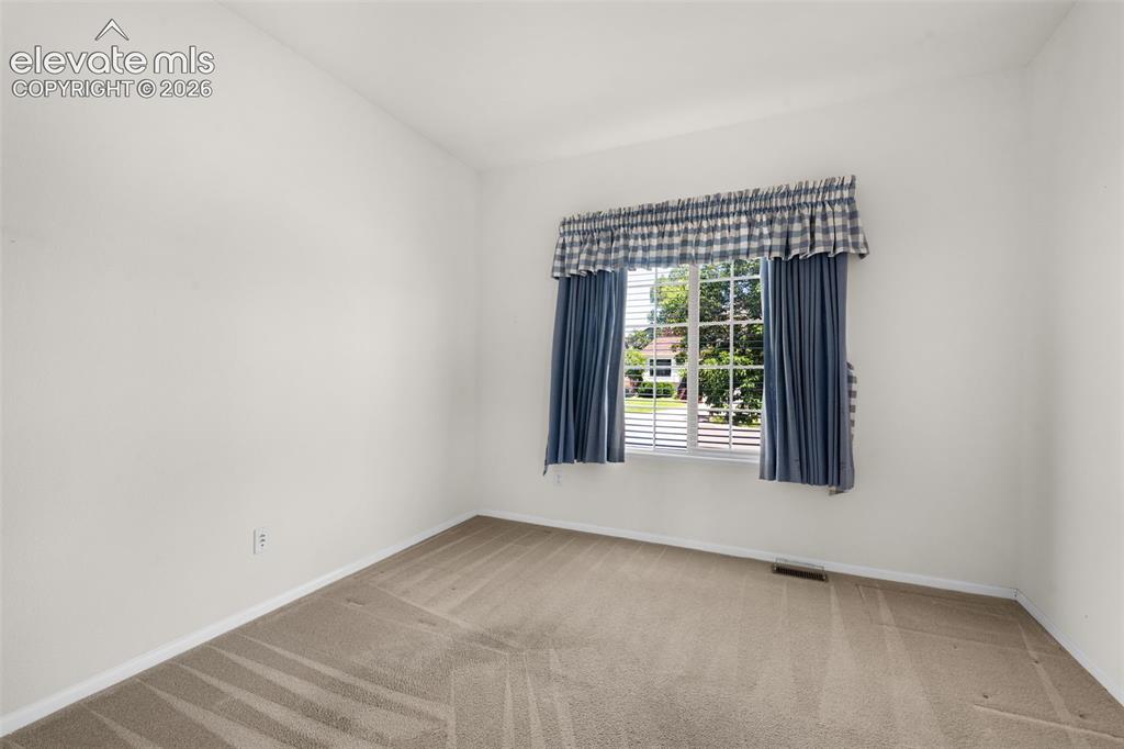 Image 23 of 46: Third Bedroom Located Off of the Living Room, Featuring French Doors and Wa