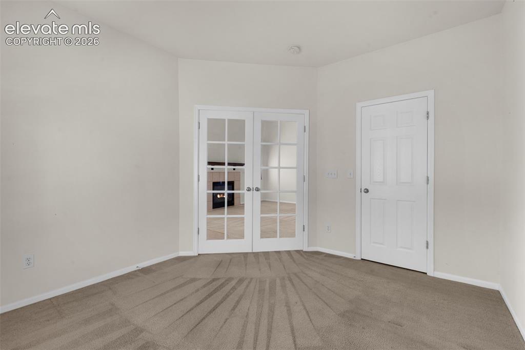 Image 25 of 46: Third Bedroom or Office Located Off of Living Room, Featuring French Doors 