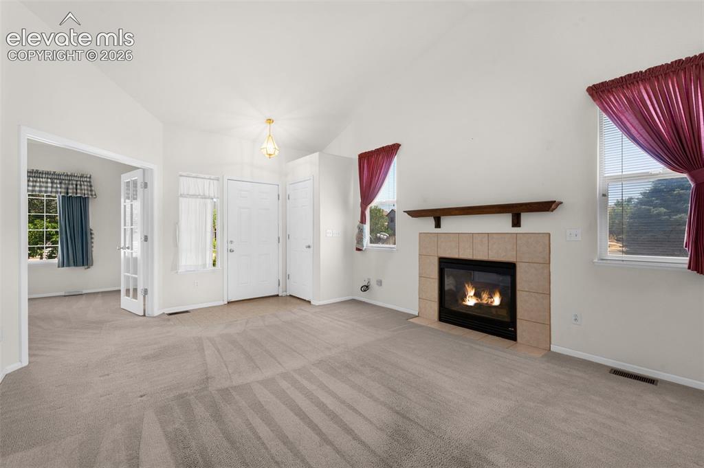 Image 8 of 46: Living Room and Entry Showing French Doors Into Third Bedroom or Office