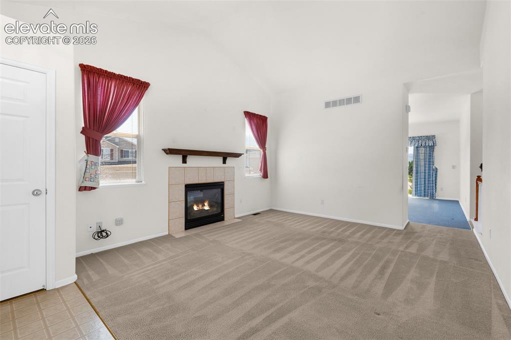 Image 9 of 46: Living Room and Entry Featuring Gas Log Fireplace, Vaulted Ceilings and Lot