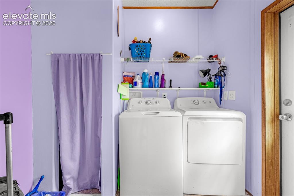 Image 18 of 38: Dedicated laundry area featuring a full-size washer and dryer