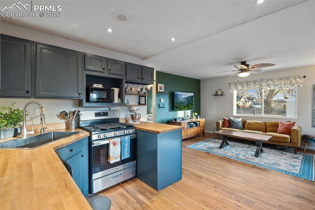 Image 12 of 37: Kitchen with butcher block counters, gas range, light wood-type flooring, a