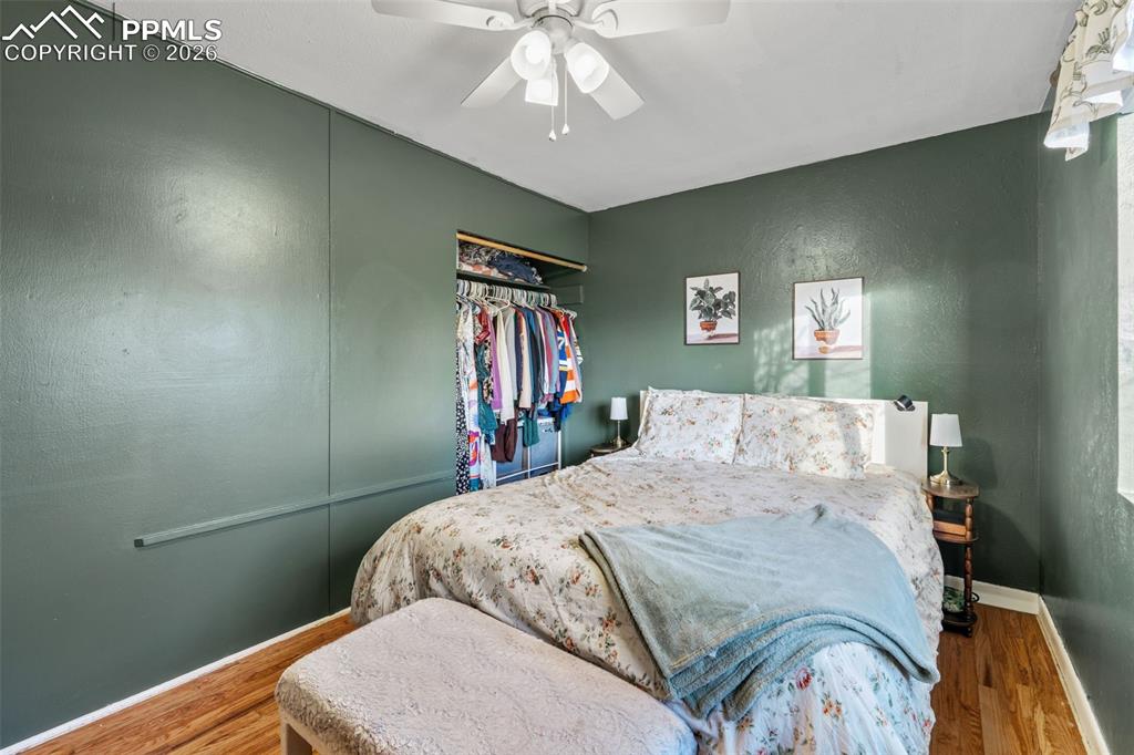 Image 16 of 37: Bedroom featuring a textured wall, a ceiling fan, and wood finished floors