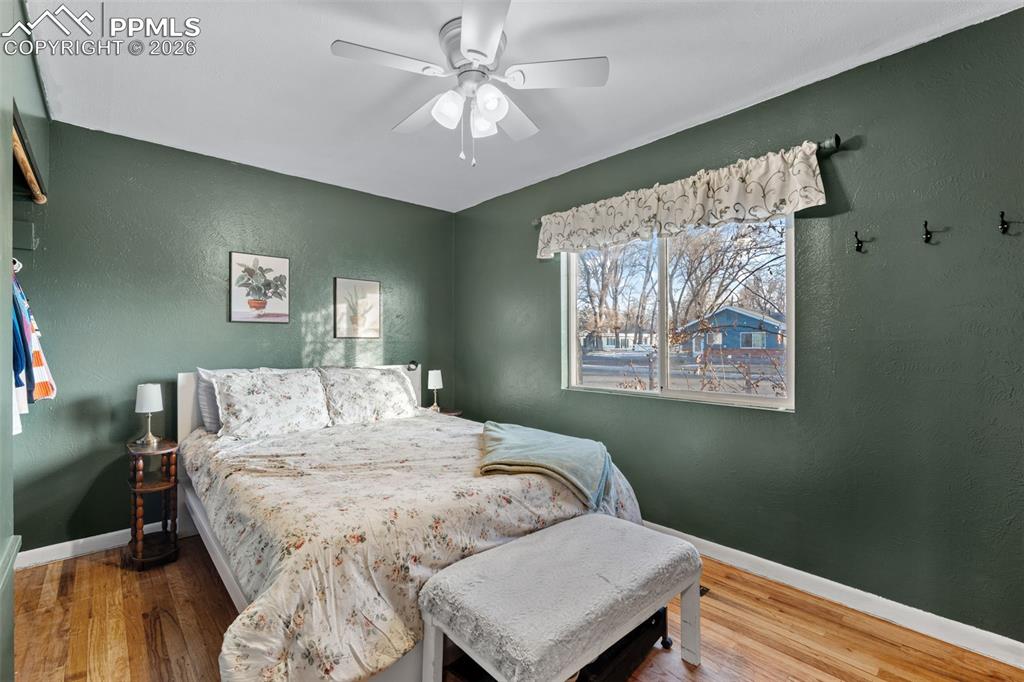 Image 17 of 37: Bedroom with a textured wall, wood finished floors, and ceiling fan