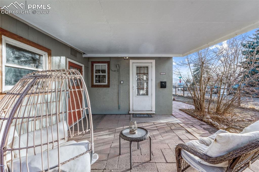 Image 23 of 37: View of exterior entry with a patio area and stucco siding