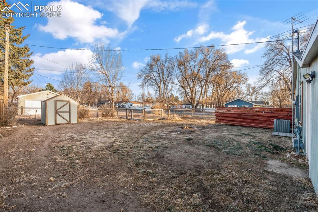 Image 30 of 37: Fenced backyard with a shed