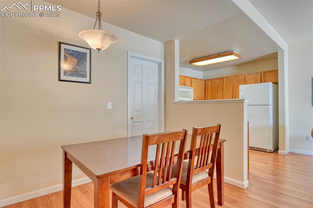 Image 12 of 32: Dining space featuring light wood-type flooring and baseboards