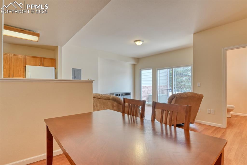 Image 14 of 32: Dining room with light wood-style floors and electric panel