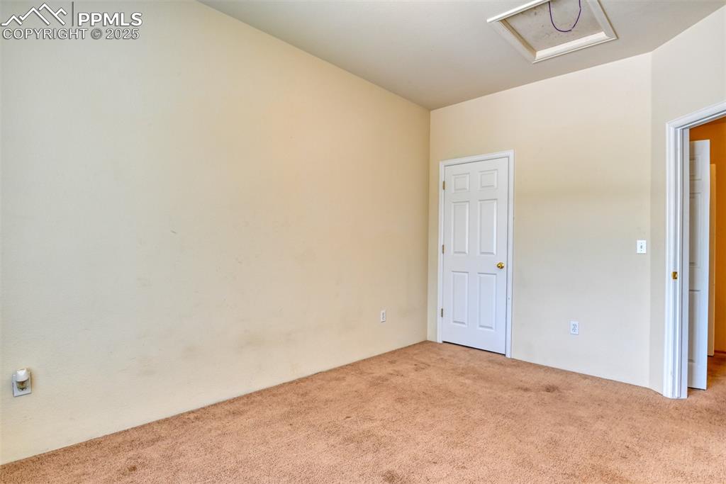 Image 22 of 32: Unfurnished room featuring carpet floors and attic access
