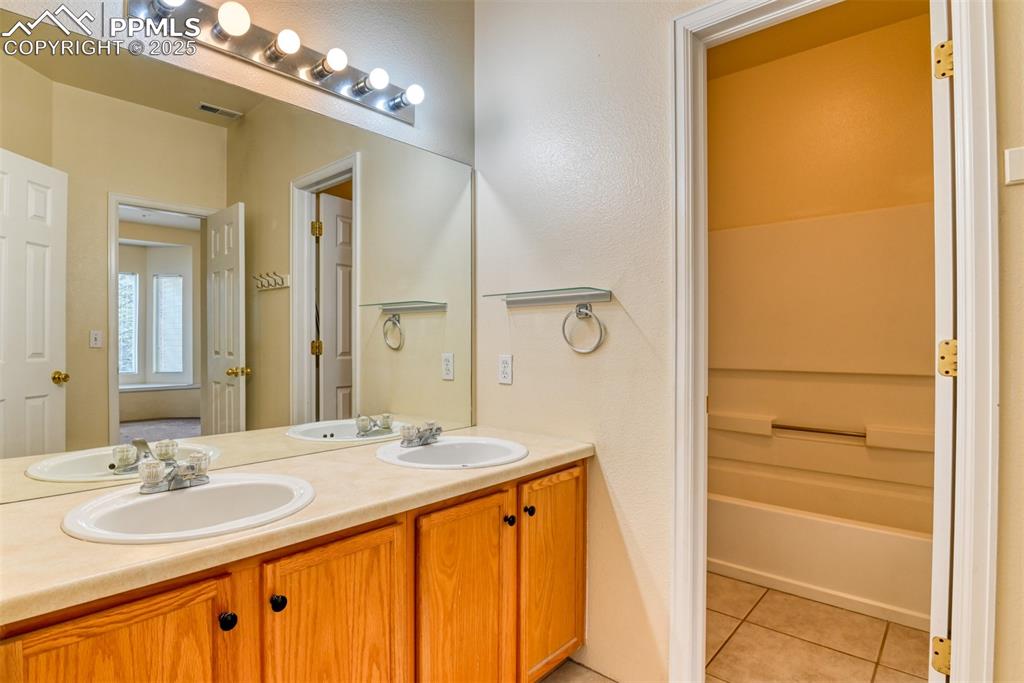 Image 23 of 32: Bathroom featuring double vanity and tile patterned floors