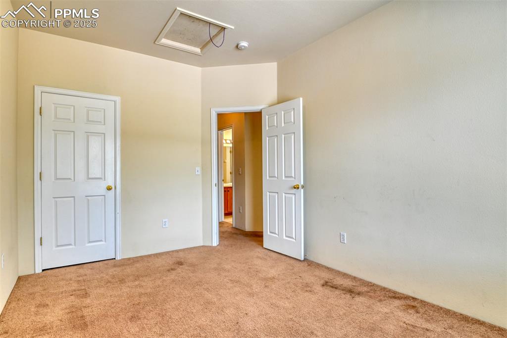 Image 24 of 32: Unfurnished bedroom featuring carpet floors and attic access