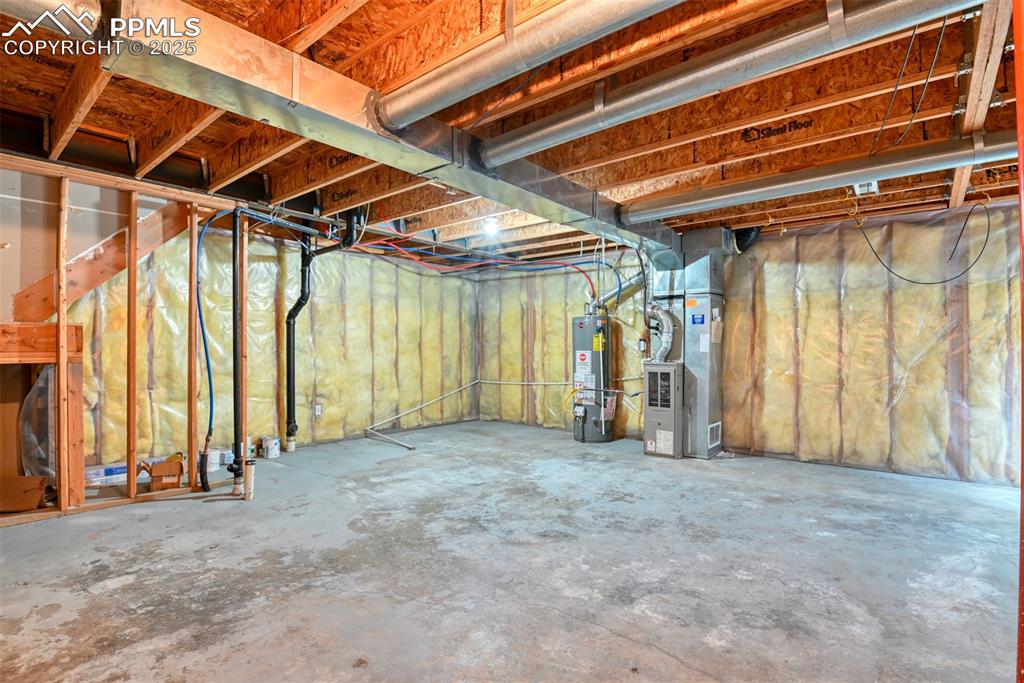 Image 31 of 32: Unfinished below grade area with water heater and heating unit