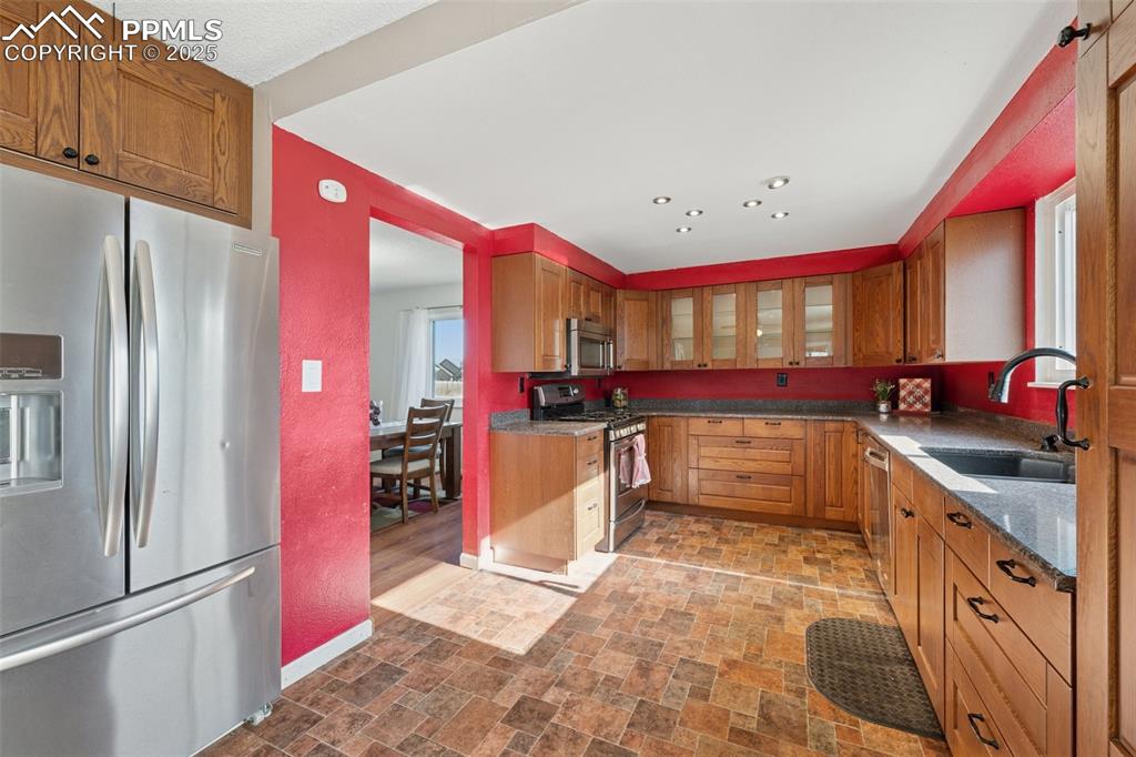Image 14 of 41: Kitchen featuring appliances with stainless steel finishes, brown cabinets,