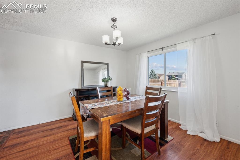 Image 17 of 41: Dining space featuring a textured ceiling, dark wood-style flooring, and a 