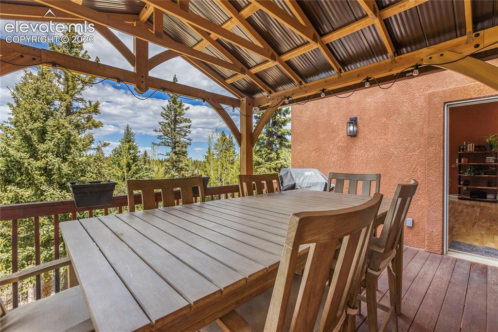 Image 13 of 40: Covered deck provides a comfortable space for outdoor dining and entertaini
