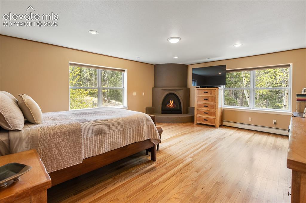 Image 16 of 40: Spacious room featuring hardwood flooring, multiple windows, recessed light