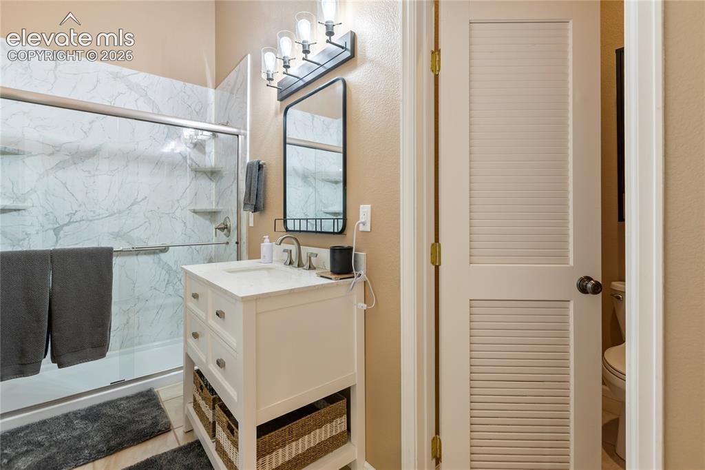 Image 23 of 40: Bathroom featuring a white vanity with integrated sink, a rectangular mirro