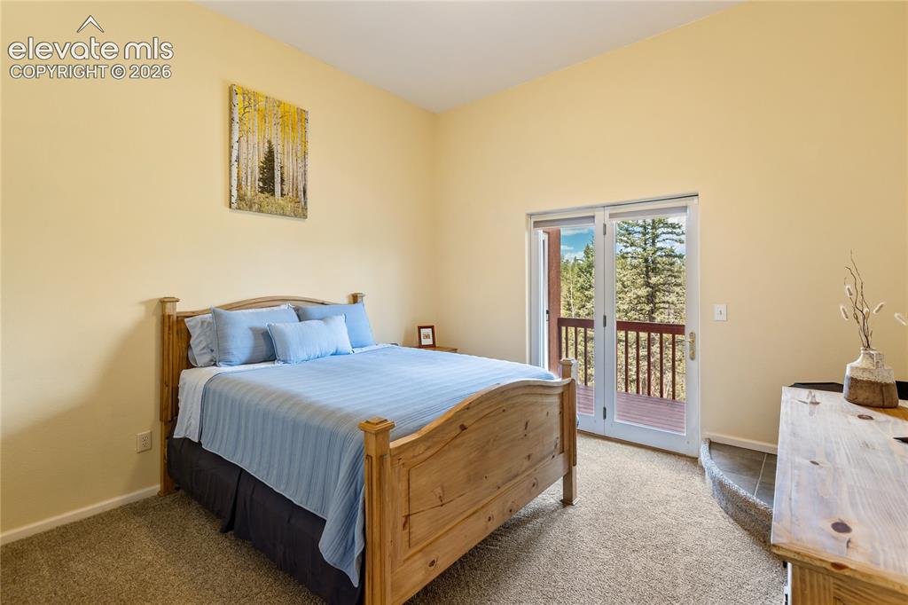Image 24 of 40: Bright upper-level bedroom with French doors to a private deck!