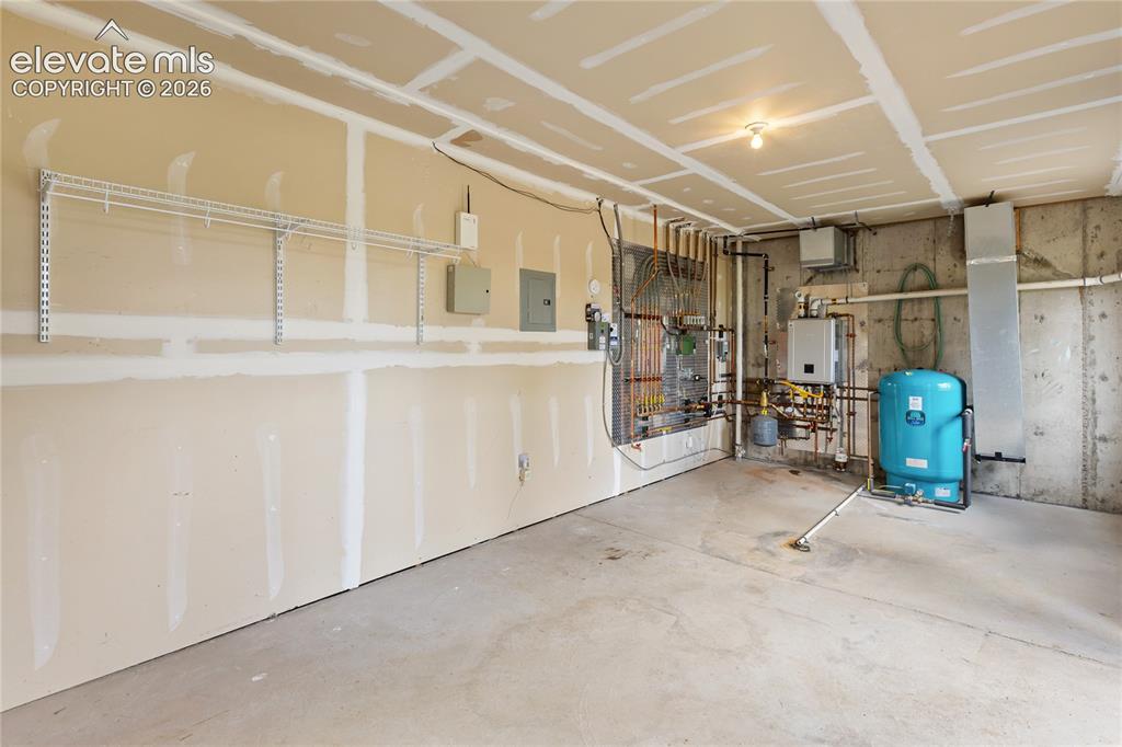 Image 28 of 40: Utility room featuring concrete flooring, exposed mechanical systems, and w