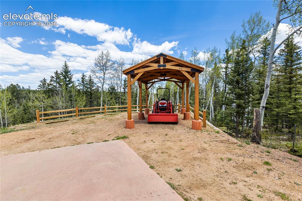 Image 37 of 40: Wood-frame structure with exposed beams atop a natural landscape
