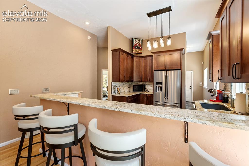 Image 9 of 40: Breakfast bar with seating opens to the gourmet kitchen!