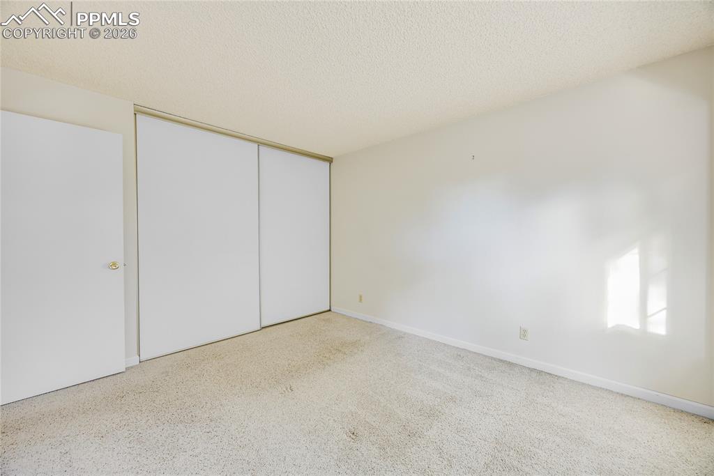 Image 13 of 17: Unfurnished bedroom with a textured ceiling and a closet
