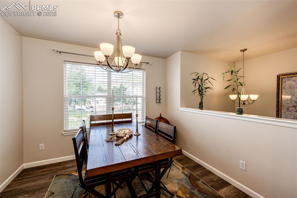Image 11 of 34: Dining room with a chandelier and dark wood-style flooring