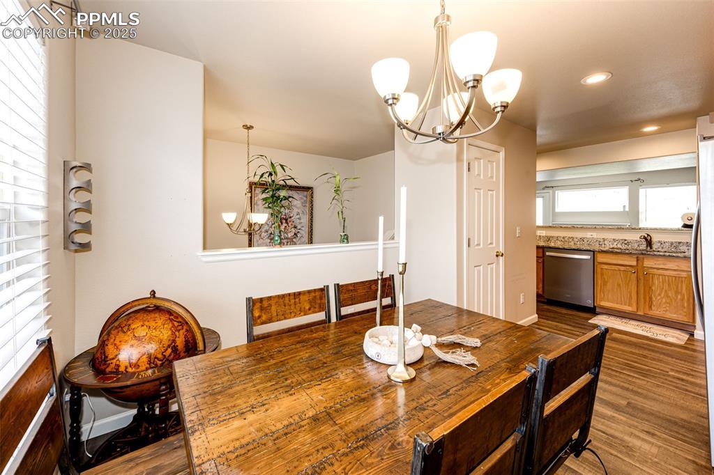 Image 12 of 34: Dining space with a chandelier, wood finished floors, and recessed lighting