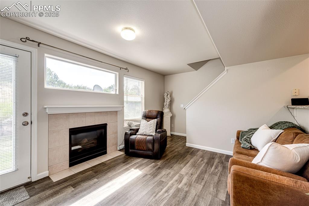 Image 5 of 34: Living room with wood finished floors and a tile fireplace