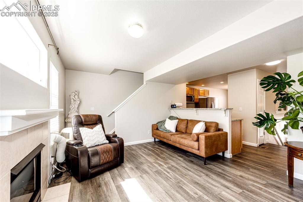 Image 7 of 34: Living room featuring wood finished floors and a fireplace