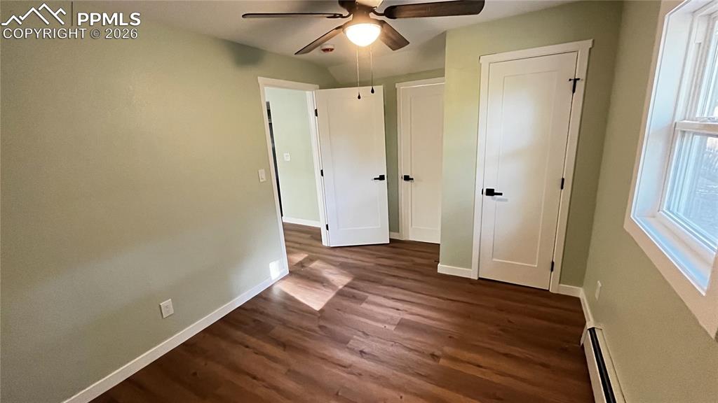 Image 11 of 18: Unfurnished main bedroom with attached bathroom with dark wood-style floor
