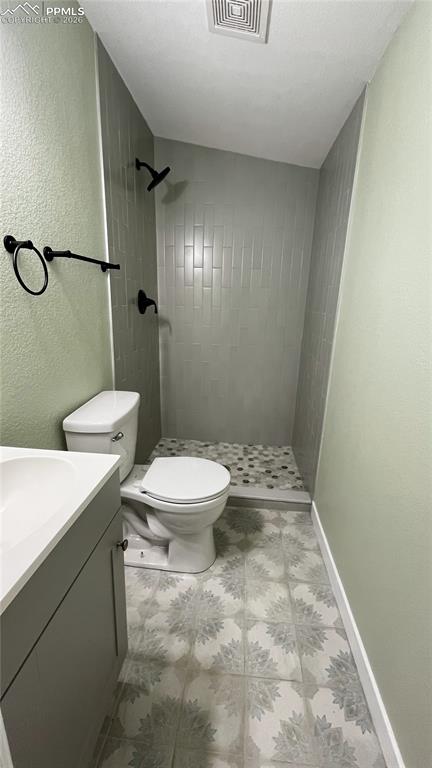 Image 12 of 18: bathroom featuring a textured wall, a shower stall, and vanity