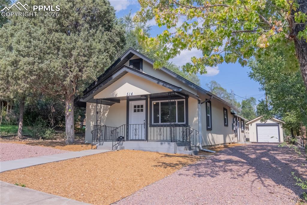 Image 2 of 18: Bungalow-style house featuring covered porch, an outbuilding, driveway, and