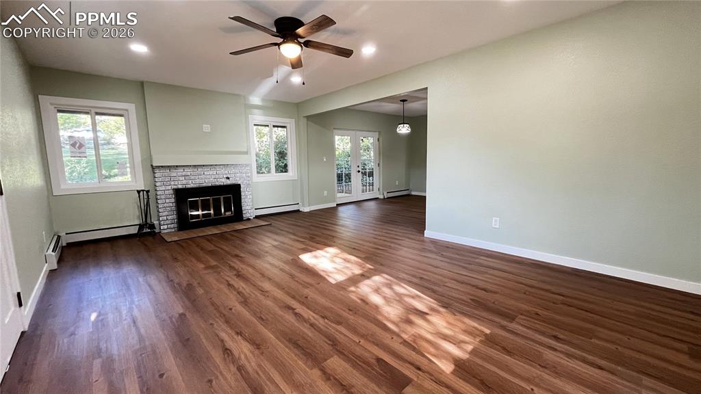 Image 5 of 18: Unfurnished living room with french doors, dark wood finished floors, ceili