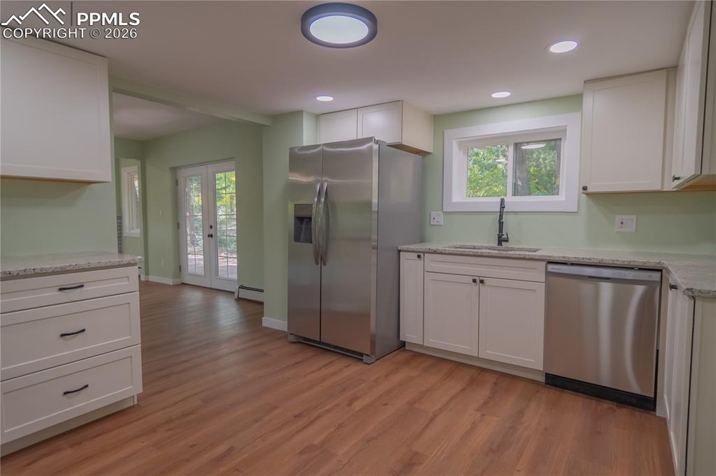 Image 8 of 18: Kitchen featuring white cabinets, appliances with stainless steel finishes,