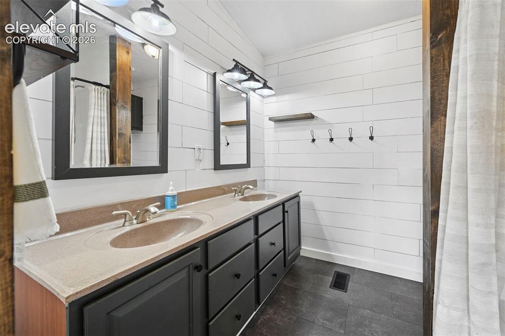 Image 22 of 44: Primary Bathroom with tile floor, shiplap walls and soaking tub/shower