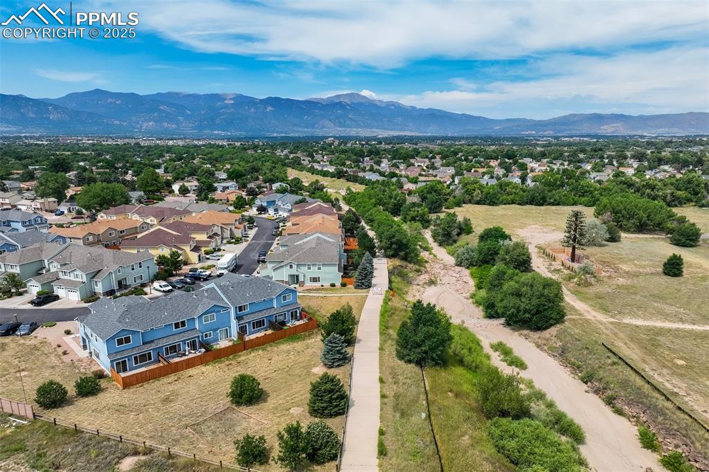 Image 37 of 41: Blue building , 2nd unit from left, large open space behind, gate access to