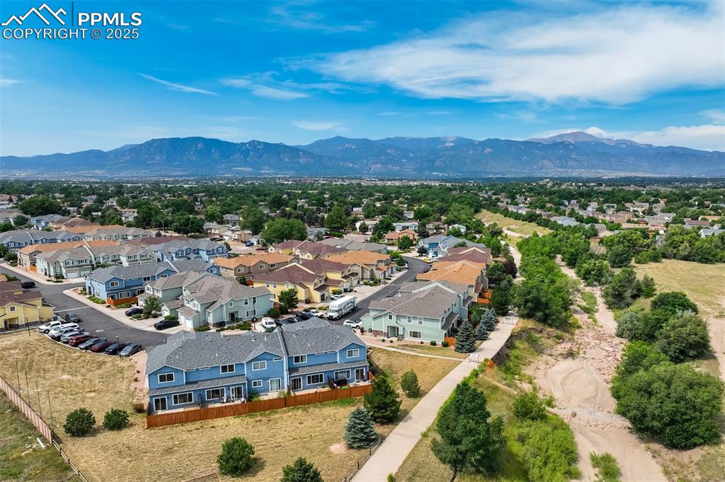Image 38 of 41: Blue building , 2nd unit from left, large open space behind, gate access to