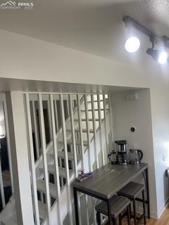 Image 24 of 30: Staircase featuring a textured ceiling and wood finished floors