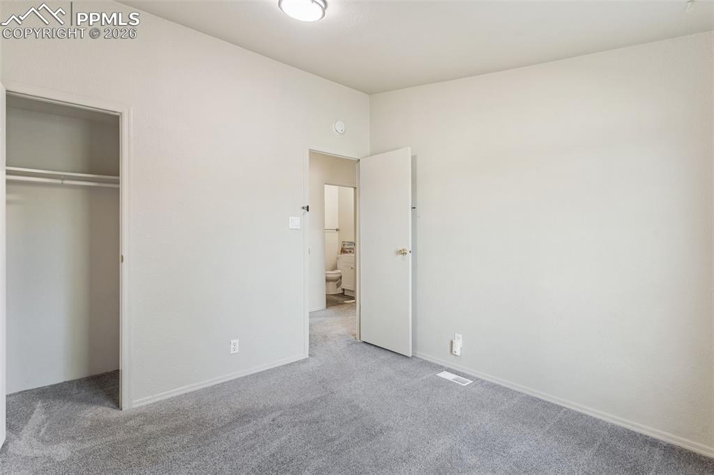 Image 12 of 18: The primary bedroom features vaulted ceilings, an oversized closet and a pr