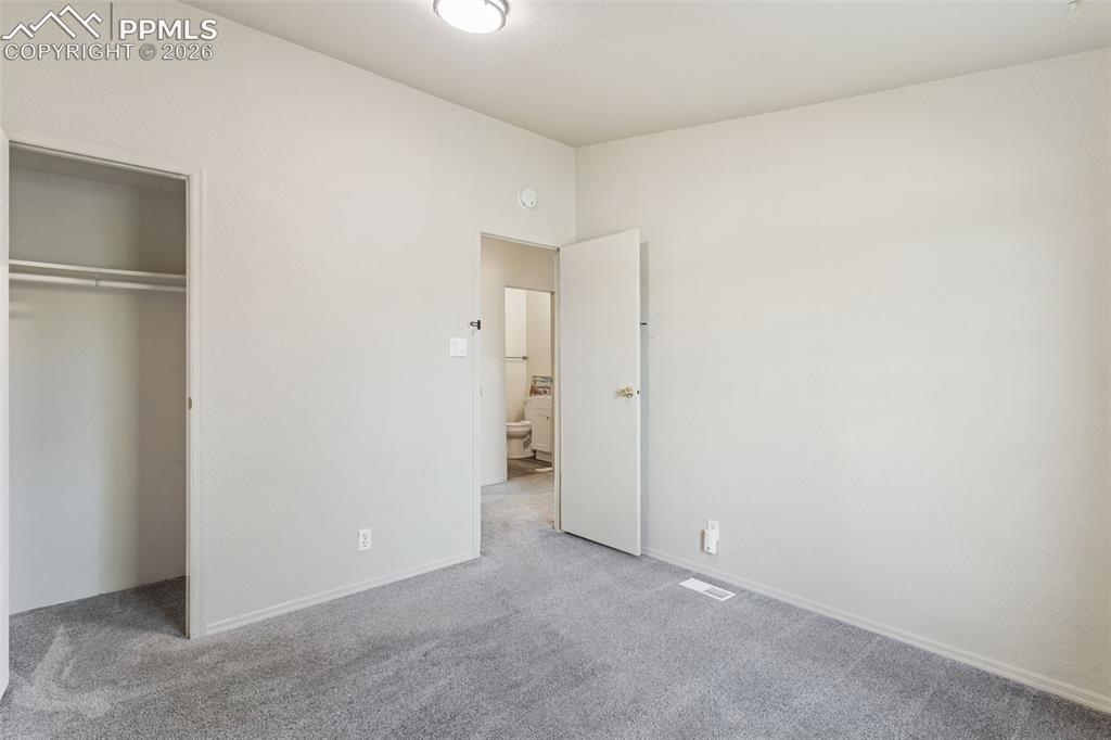 Image 19 of 28: The primary bedroom features vaulted ceilings, an oversized closet and a pr