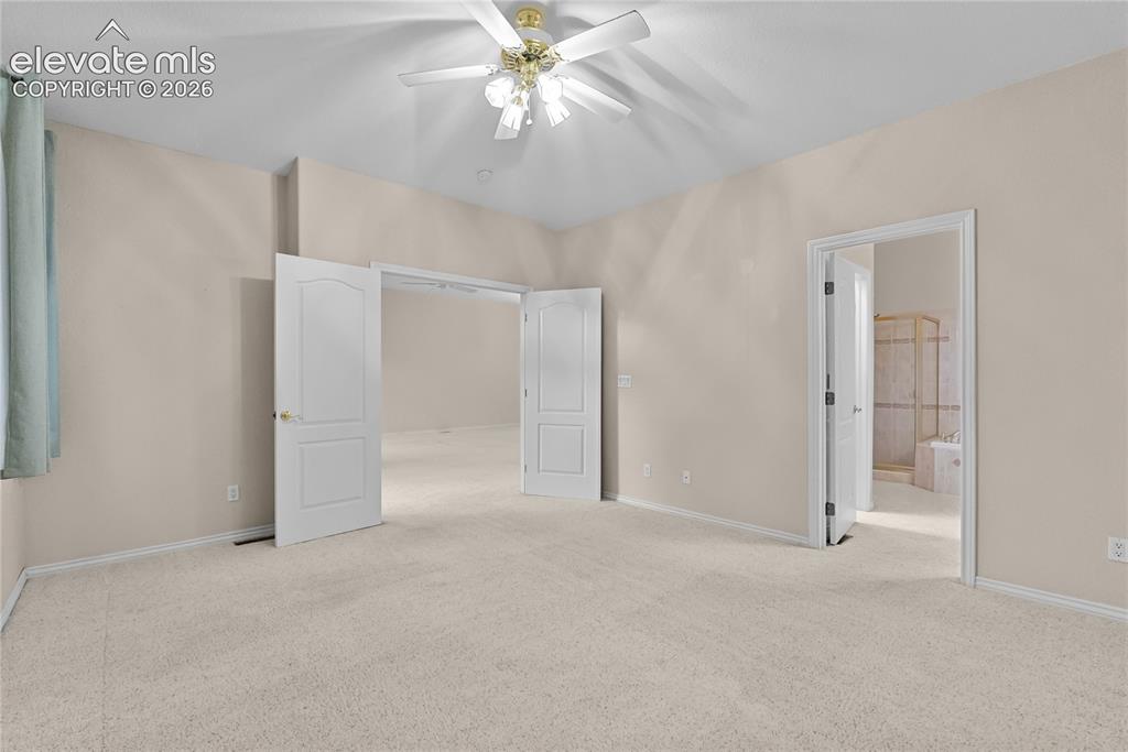 Image 13 of 41: Spacious room with plush carpeting and neutral wall tones