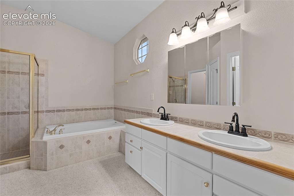 Image 14 of 41: Bathroom featuring a dual vanity with white cabinetry, light-toned countert