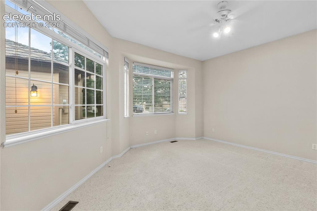 Image 19 of 41: Spacious room featuring light-colored carpet flooring, a ceiling-mounted li