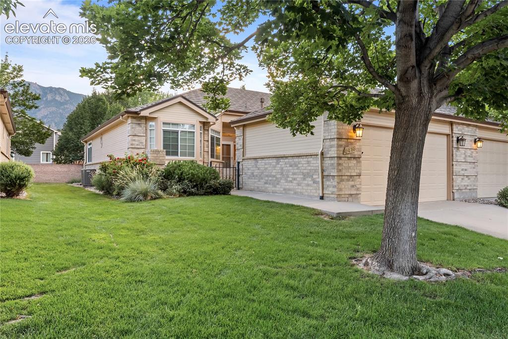 Image 2 of 41: Exterior featuring beige siding, light-colored brick accents, multiple gara