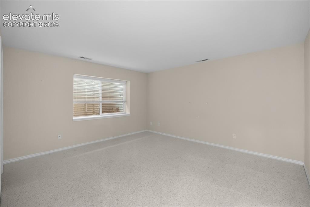 Image 26 of 41: Neutral-toned carpeting, light beige wall paint, white trim, and a window w