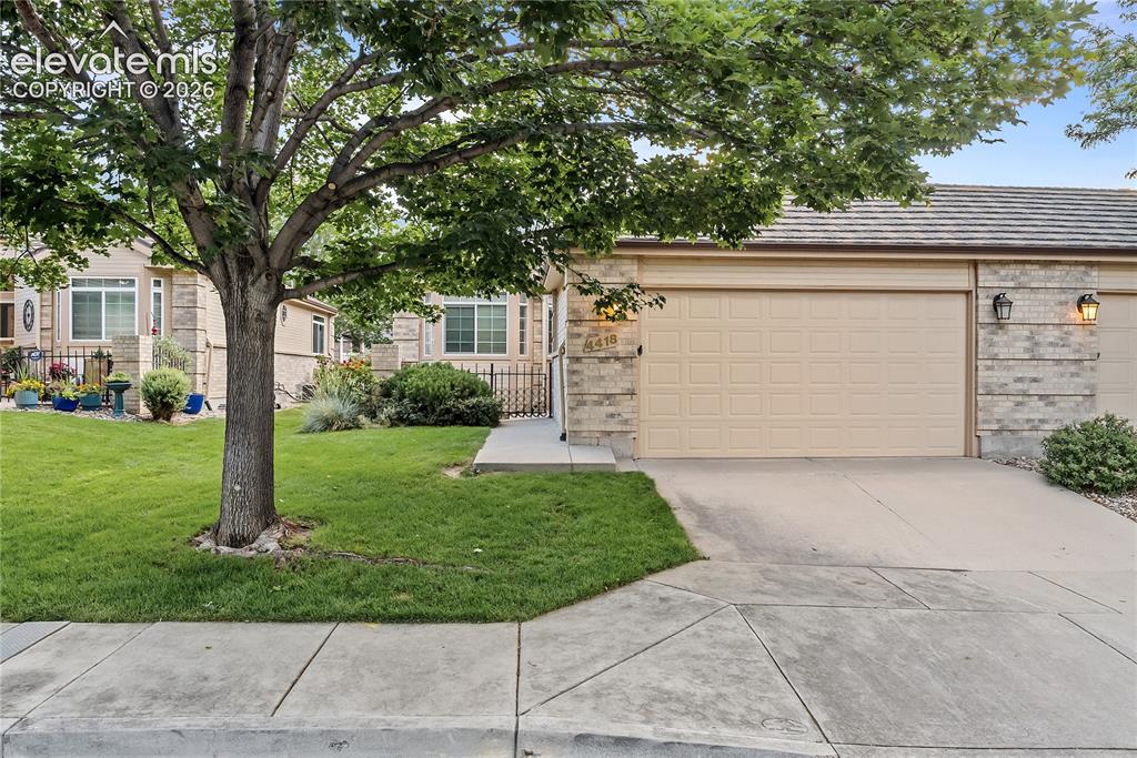 Image 3 of 41: Garage-front exterior featuring a tan sectional door and brick-patterned si