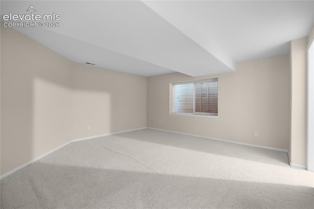 Image 32 of 41: Spacious room featuring neutral carpeting and light-toned wall paint